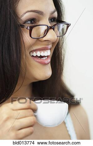 Picture - Close up of woman in glasses drinking coffee. Fotosearch
