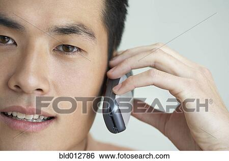 Stock Photograph - Close up of young man with mobile phone. Fotosearch