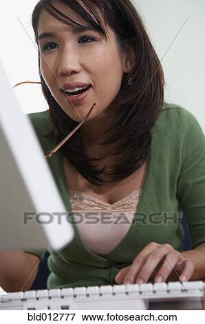 Close-up of young woman at computer View Large Photo Image Stock Photo - Close-up of young woman at computer. Fotosearch
