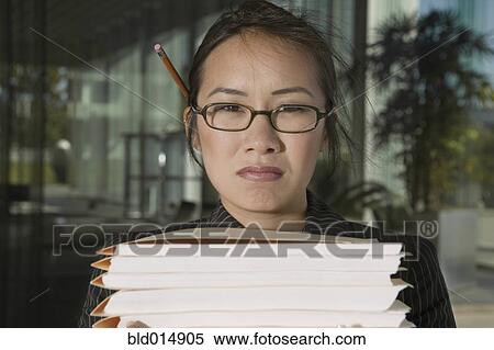 Stock Photography - Close up portrait of frustrated businesswoman with stacks of files. Fotosearch
