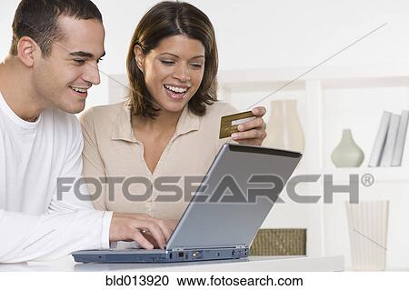 Couple ordering online with credit card and laptop View Large Photo Image Stock Image - Couple ordering online with credit card and laptop. Fotosearch