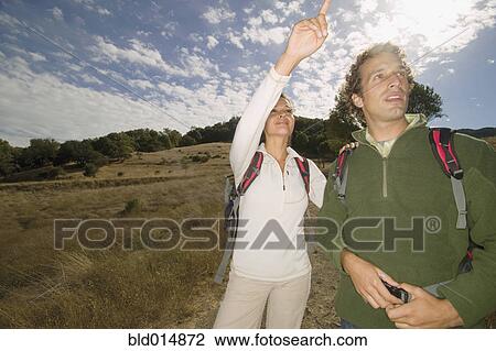 Stock Image - Couple pointing while hiking. Fotosearch