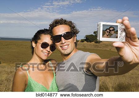 Stock Photo - Couple taking self-portrait with camera. Fotosearch