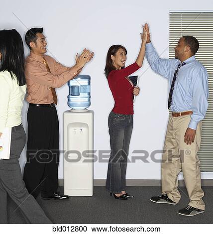 Stock Image - Coworkers congratulating each other. Fotosearch