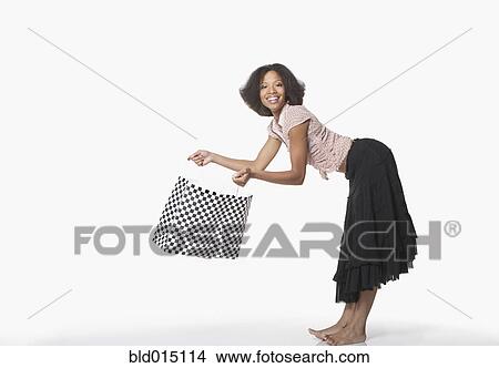 Full view portrait of woman bending over while holding shopping bag View Large Photo Image Picture - Full view portrait of woman bending over while holding shopping bag. Fotosearch