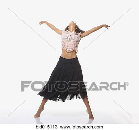 Stock Image - Full view portrait of woman dancing with hands raised. Fotosearch