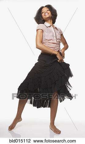 Stock Image - Full view portrait of woman in skirt dancing. Fotosearch