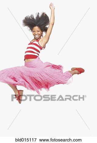 Stock Photo - Full view portrait of woman in skirt jumping up. Fotosearch