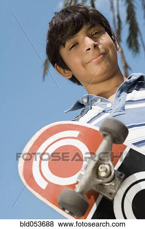 Hispanic boy holding skateboard View Large Photo Image Stock Photo - Hispanic boy holding skateboard. Fotosearch
