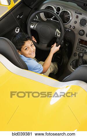 Stock Image - Hispanic boy sitting in new car. Fotosearch