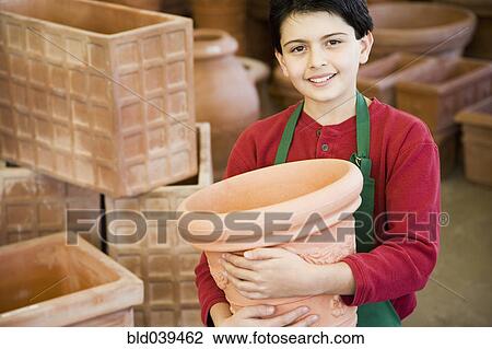Stock Image - Hispanic boy working at garden center. Fotosearch