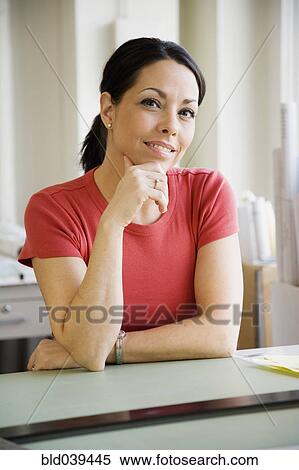 Stock Photography - Hispanic businesswoman at desk. Fotosearch