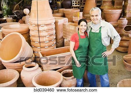 Stock Image - Hispanic couple working at garden center. Fotosearch