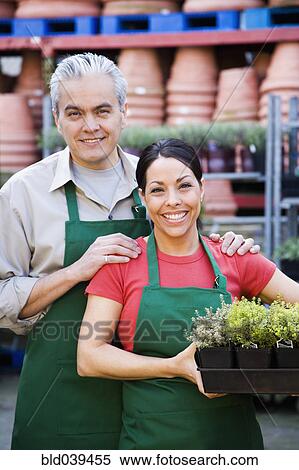 Stock Photography - Hispanic couple working at garden center. Fotosearch