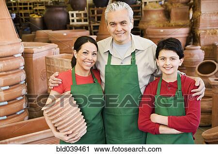 Stock Image - Hispanic family working at garden center. Fotosearch