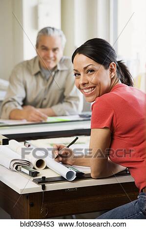 Stock Image - Hispanic female architect at desk. Fotosearch
