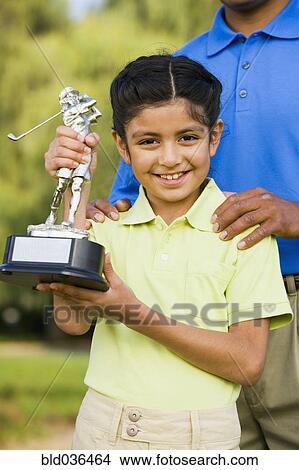 Hispanic girl holding golf trophy View Large Photo Image Picture - Hispanic girl holding golf trophy. Fotosearch