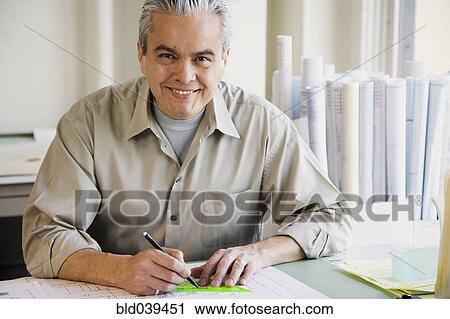 Hispanic male architect writing at desk View Large Photo Image Stock Image - Hispanic male architect writing at desk. Fotosearch