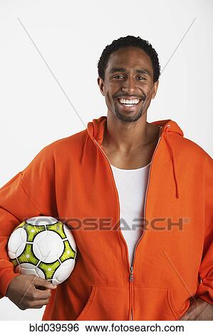 Stock Photograph - Hispanic man holding soccer ball. Fotosearch