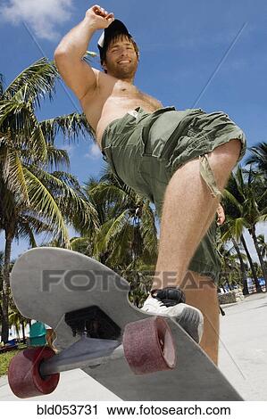 Hispanic man riding skateboard View Large Photo Image Stock Image - Hispanic man riding skateboard. Fotosearch