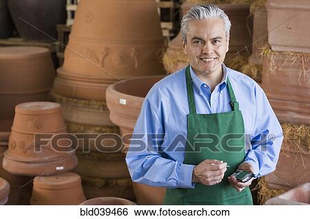 Stock Photograph - Hispanic man working at garden center. Fotosearch