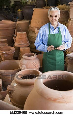 Stock Photography - Hispanic man working at garden center. Fotosearch