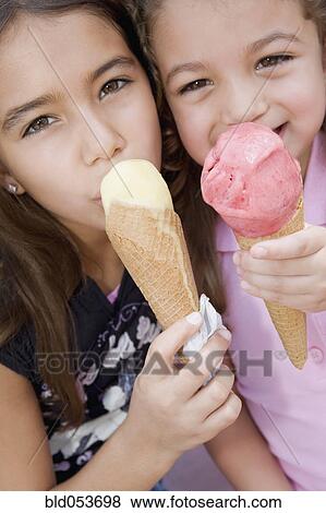 Hispanic sisters eating ice cream cones View Large Photo Image Stock Photo - Hispanic sisters eating ice cream cones. Fotosearch