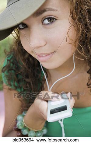 Picture - Hispanic teenaged girl holding mp3 player. Fotosearch