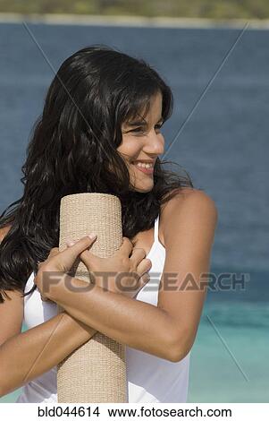 Hispanic woman holding beach mat View Large Photo Image Picture - Hispanic woman holding beach mat. Fotosearch