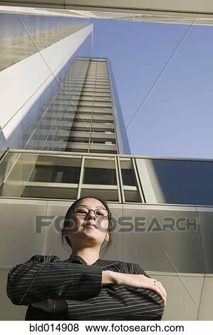 Low angle view of businesswoman in front of highrise View Large Photo Image Stock Photo - Low angle view of businesswoman in front of highrise. Fotosearch