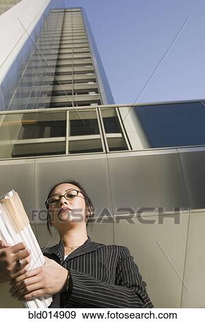 Low angle view of businesswoman in front of highrise View Large Photo Image Stock Photo - Low angle view of businesswoman in front of highrise. Fotosearch