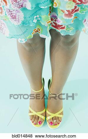 Stock Photo - Low section of woman in dress and high heels. Fotosearch