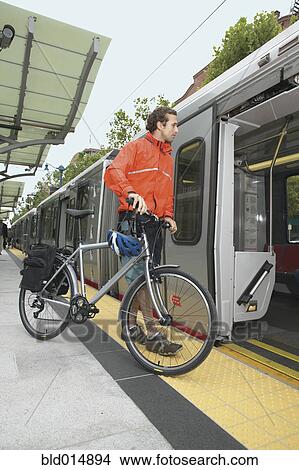 Picture - Man boarding subway with bike. Fotosearch