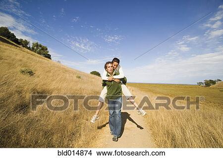 Picture - Man giving woman piggy back ride . Fotosearch