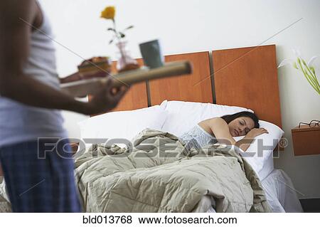 Man serving breakfast in bed to sleeping woman View Large Photo Image Stock Photo - Man serving breakfast in bed to sleeping woman. Fotosearch