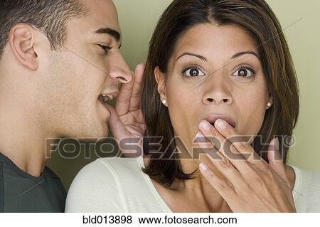 Stock Photo - Man whispering into woman's ear. Fotosearch