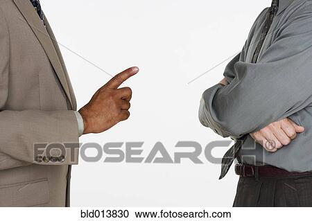 Stock Image - Mid section of two businessmen facing each other. Fotosearch