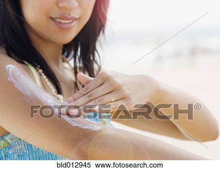 Mid section of woman applying lotion to arm View Large Photo Image Stock Photography - Mid section of woman applying lotion to arm. Fotosearch