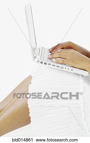 Mid section of woman balancing laptop on knees and typing View Large Photo Image Stock Image - Mid section of woman balancing laptop on knees and typing. Fotosearch