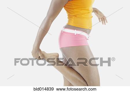 Mid section of woman stretching View Large Photo Image Stock Photo - Mid section of woman stretching. Fotosearch