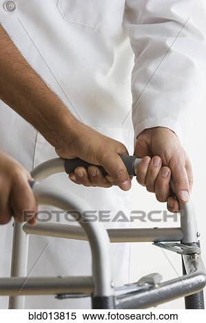 Mid view of doctor assisting patient with walker View Large Photo Image Stock Photography - Mid view of doctor assisting patient with walker. Fotosearch