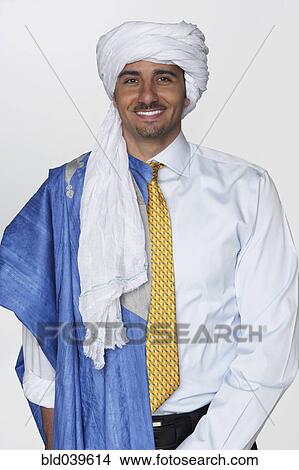 Picture - Middle Eastern man wearing traditional dress and business attire. Fotosearch