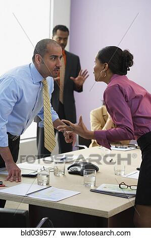 Stock Photo - Multi-ethnic businesspeople arguing across table. Fotosearch
