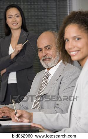 Stock Image - Multi-ethnic businesspeople at meeting. Fotosearch