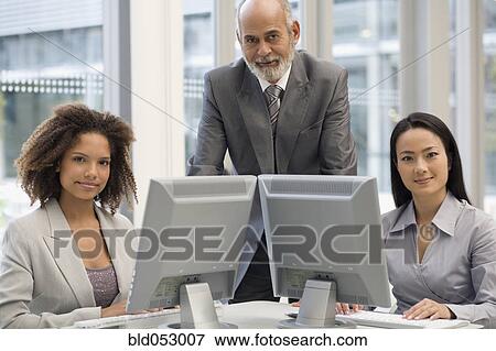 Multi-ethnic businesspeople behind computers View Large Photo Image Stock Photo - Multi-ethnic businesspeople behind computers. Fotosearch