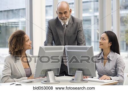 Multi-ethnic businesspeople behind computers View Large Photo Image Stock Photo - Multi-ethnic businesspeople behind computers. Fotosearch
