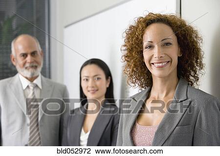 Stock Image - Multi-ethnic businesspeople next to wall. Fotosearch