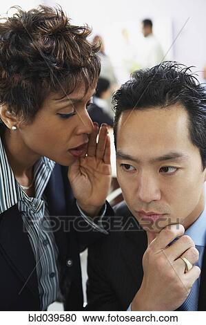 Multi-ethnic businesspeople telling secret View Large Photo Image Stock Image - Multi-ethnic businesspeople telling secret. Fotosearch