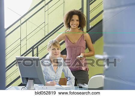 Stock Photo - Multi-ethnic businesswomen behind desk. Fotosearch