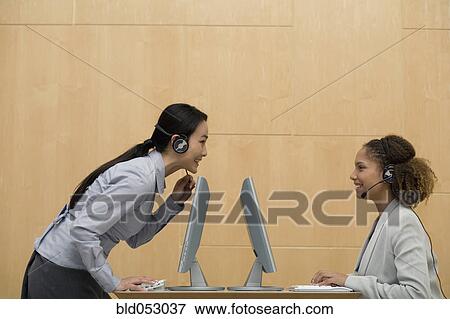 Stock Photo - Multi-ethnic businesswomen wearing headsets. Fotosearch